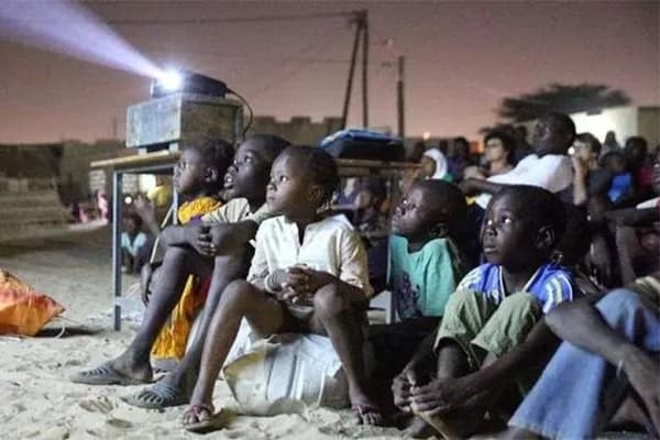Projection de film en plein air, la nuit, devant un public